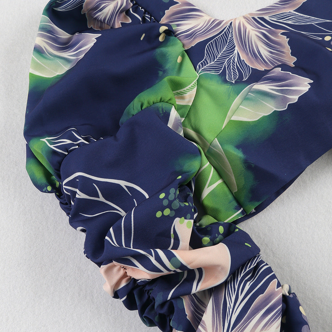 Stylish two-piece outfit consisting of a blue and white floral-print crop top with puff sleeves and a maching tiered maxi skirt.