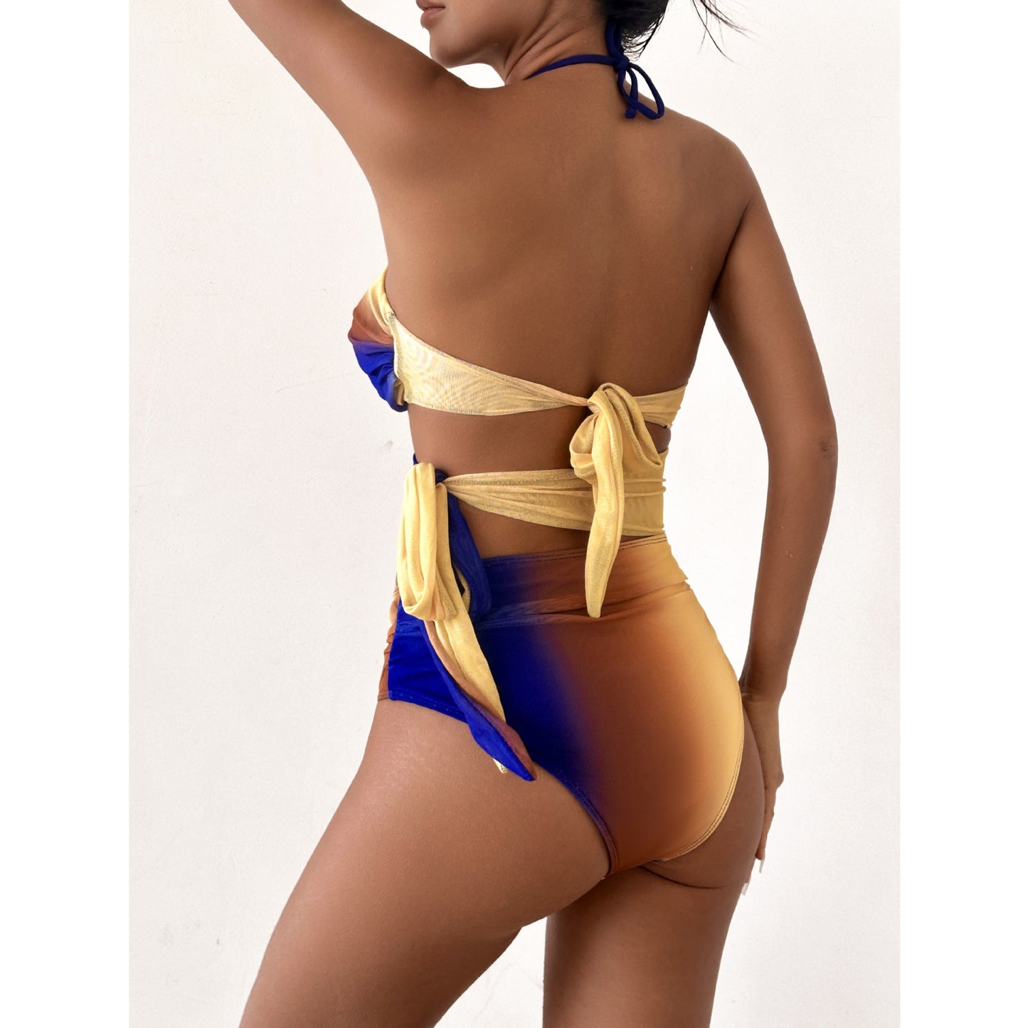 Colorful ombre dress with a halter neckline, a cutout midsection,and a high slit.