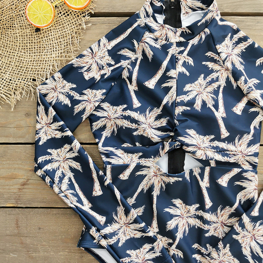 A long -sleeve,one-piece swimsuit with a blue and white palm leaf print and a zipper at the front