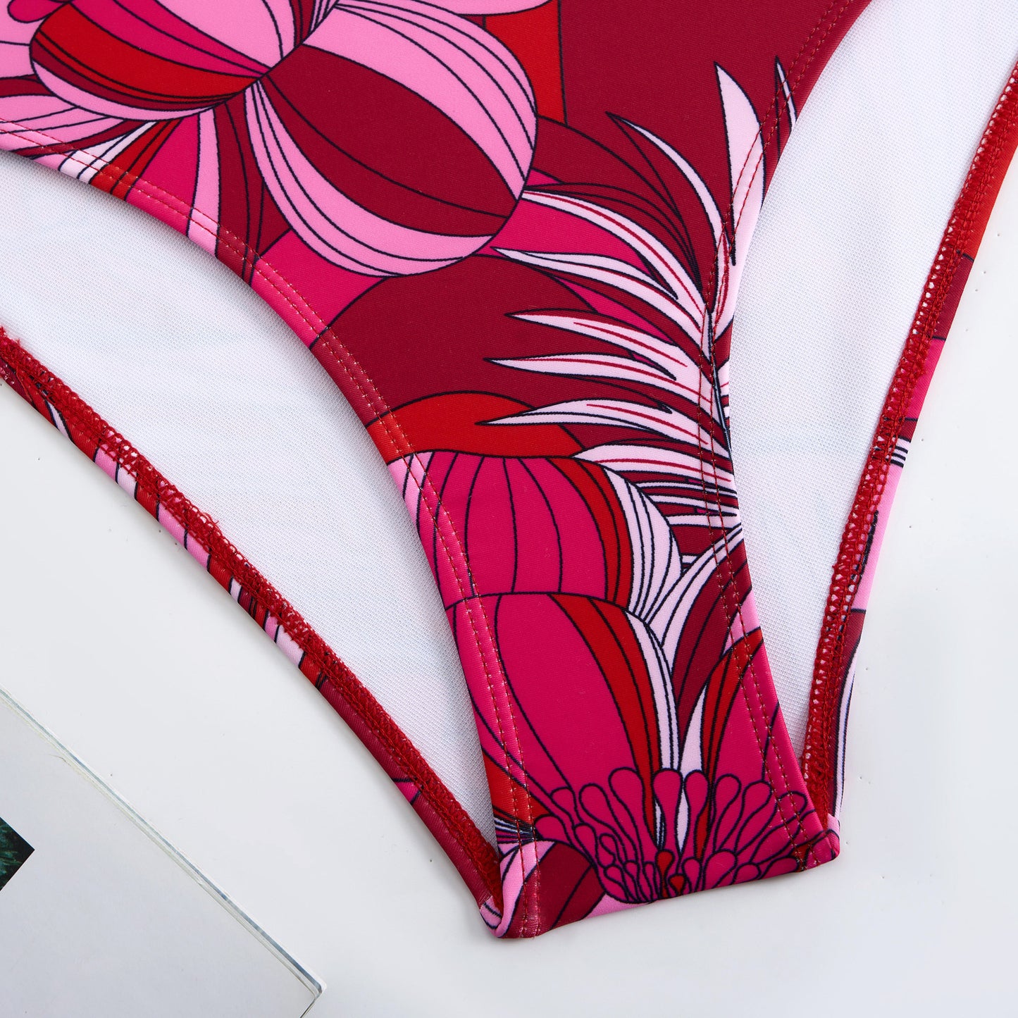 Red one-piece swimsuit with a single ruffled shoulder,paired with a matching short skirt