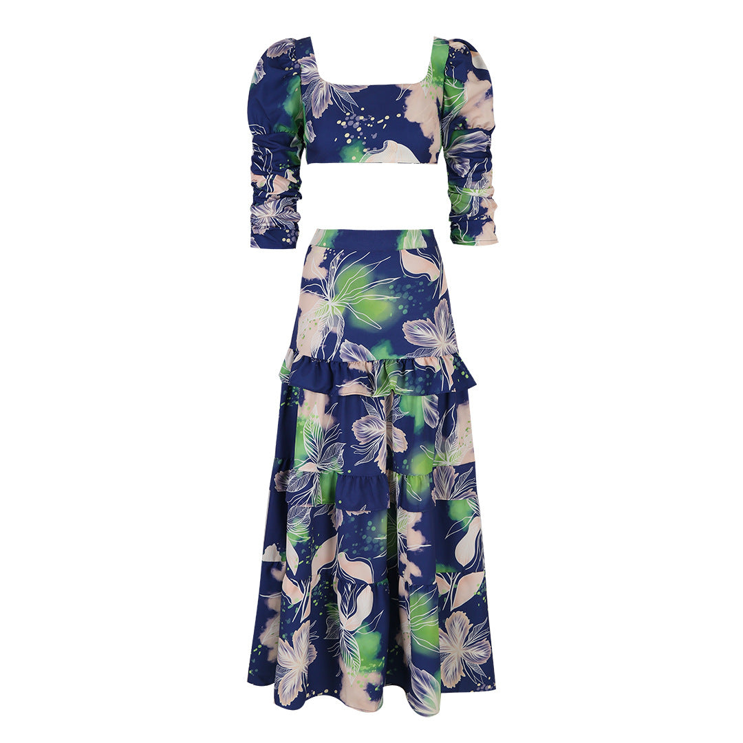 Stylish two-piece outfit consisting of a blue and white floral-print crop top with puff sleeves and a maching tiered maxi skirt.