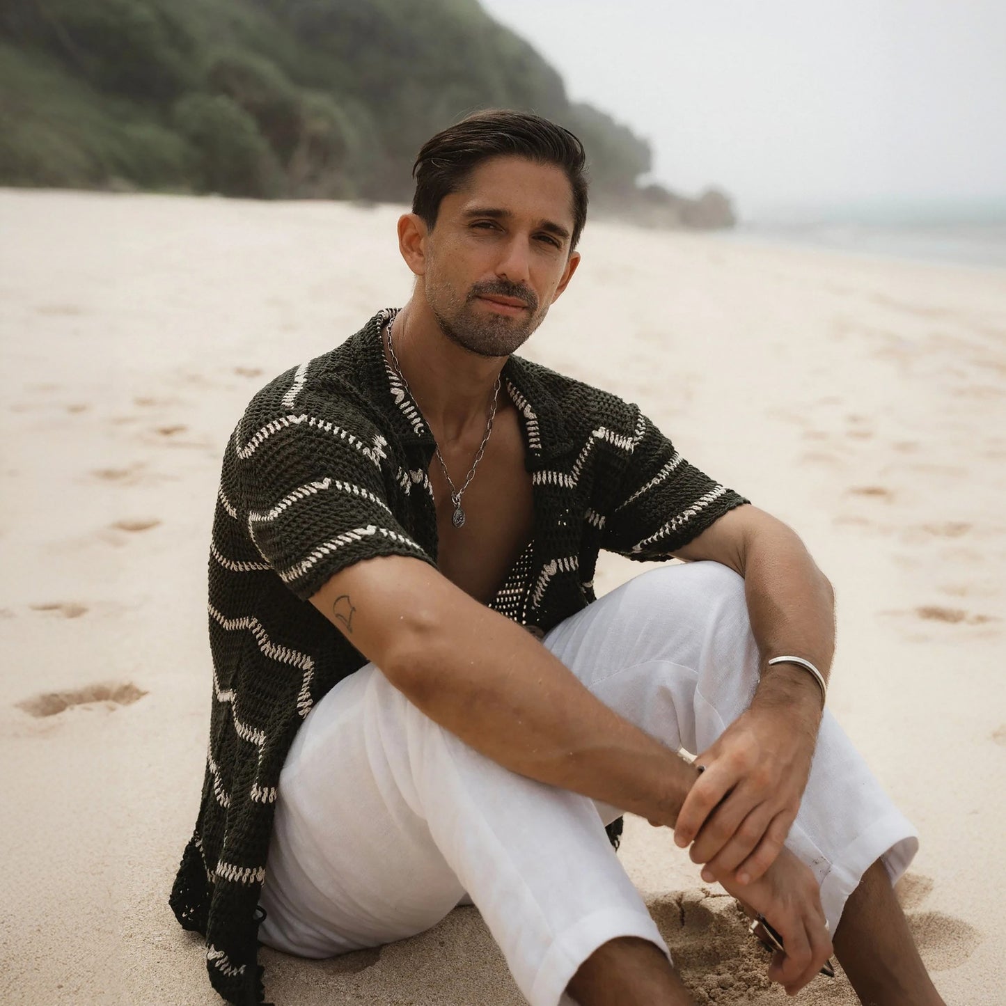 Black and white striped short sleeve shirt on a sandy beach