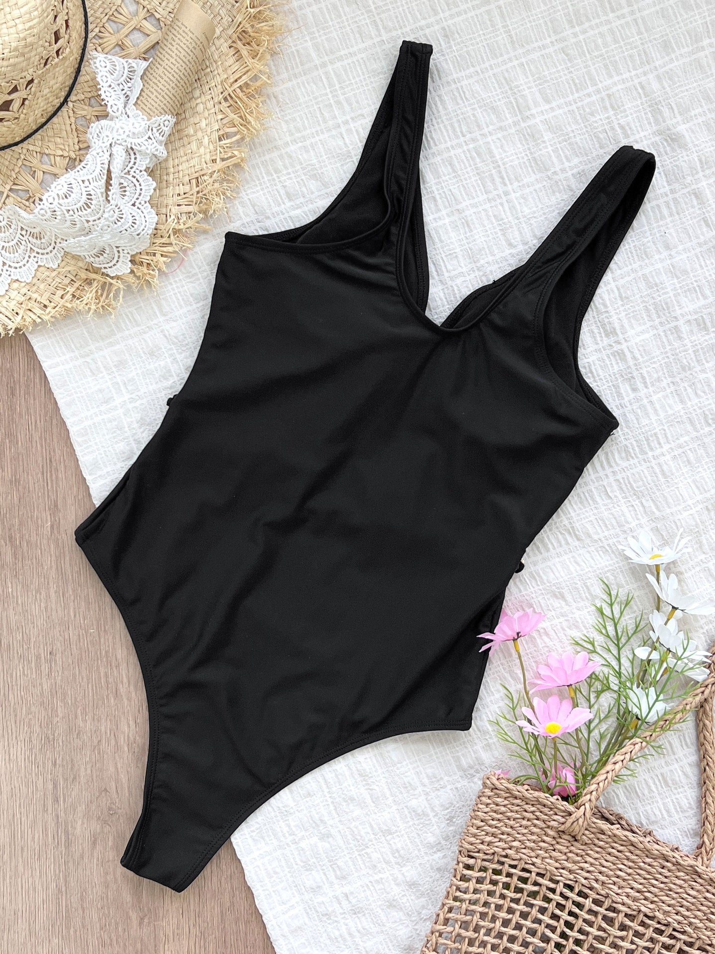 Black one-piece swimsuit with gold chain accents