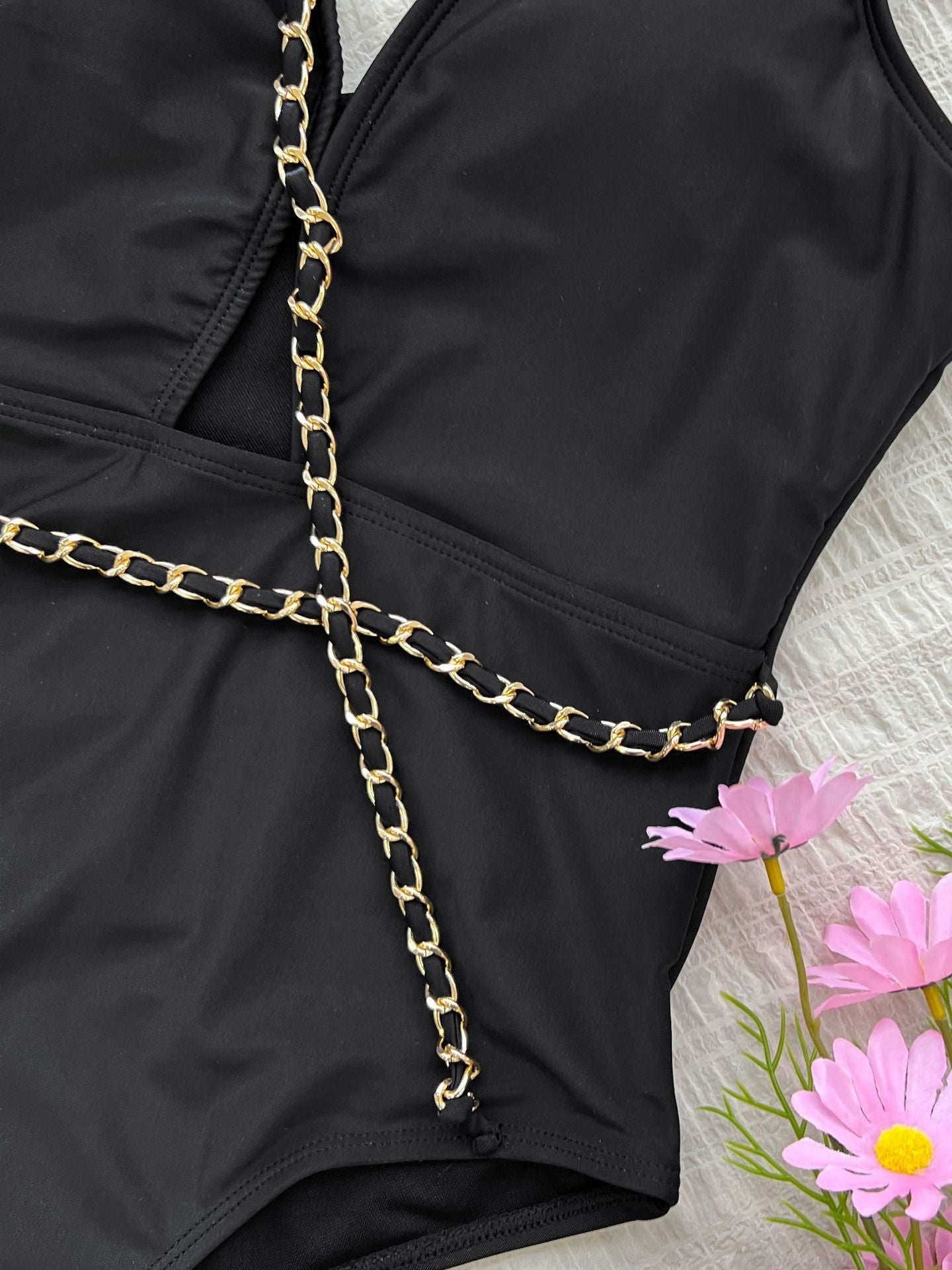 Black one-piece swimsuit with gold chain accents