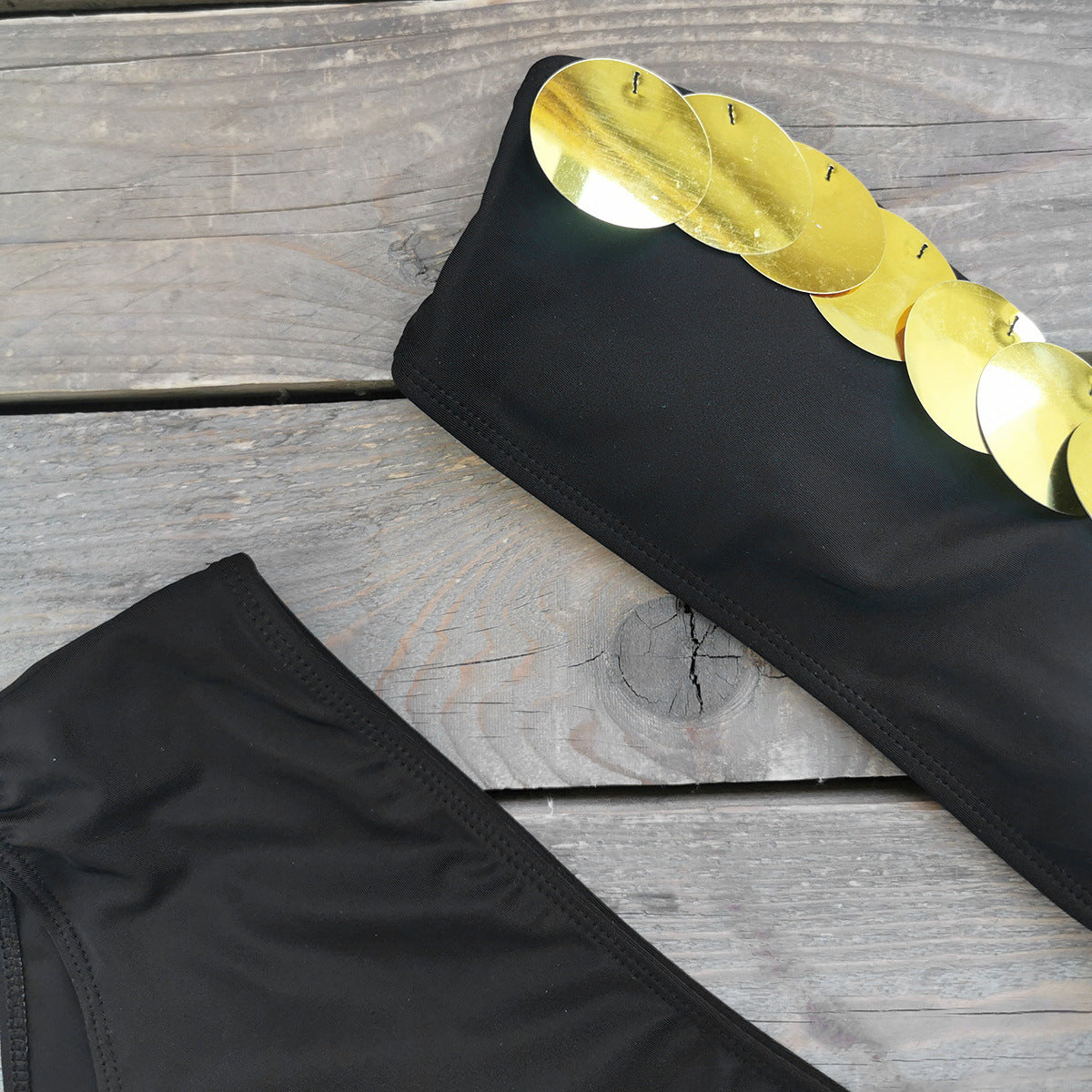 Black bandeau bikini top with a metallic gold stripe and high waisted black bikini bottoms.