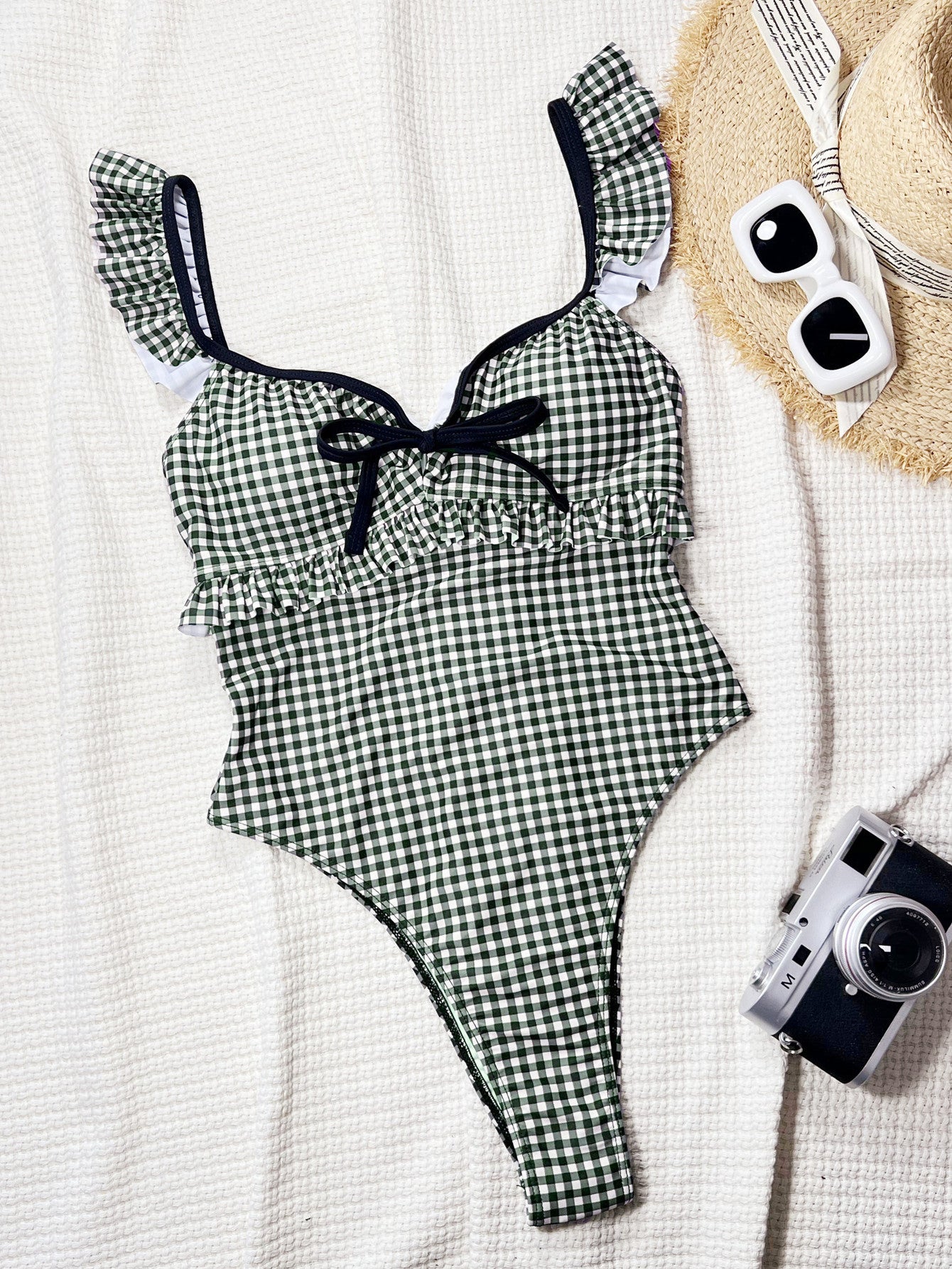 Black and white gingham one-piece swimsuit with ruffled straps.