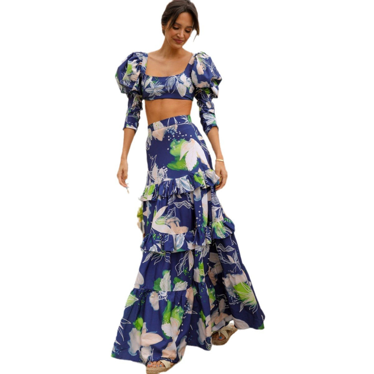 Stylish two-piece outfit consisting of a blue and white floral-print crop top with puff sleeves and a maching tiered maxi skirt.