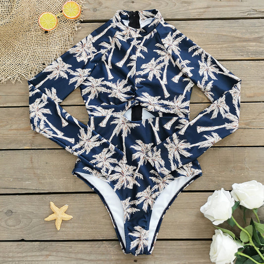 A long -sleeve,one-piece swimsuit with a blue and white palm leaf print and a zipper at the front